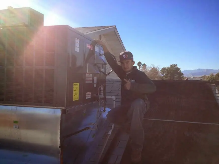 HVAC technician performing Boiler Repair on a rooftop unit in Wakefield